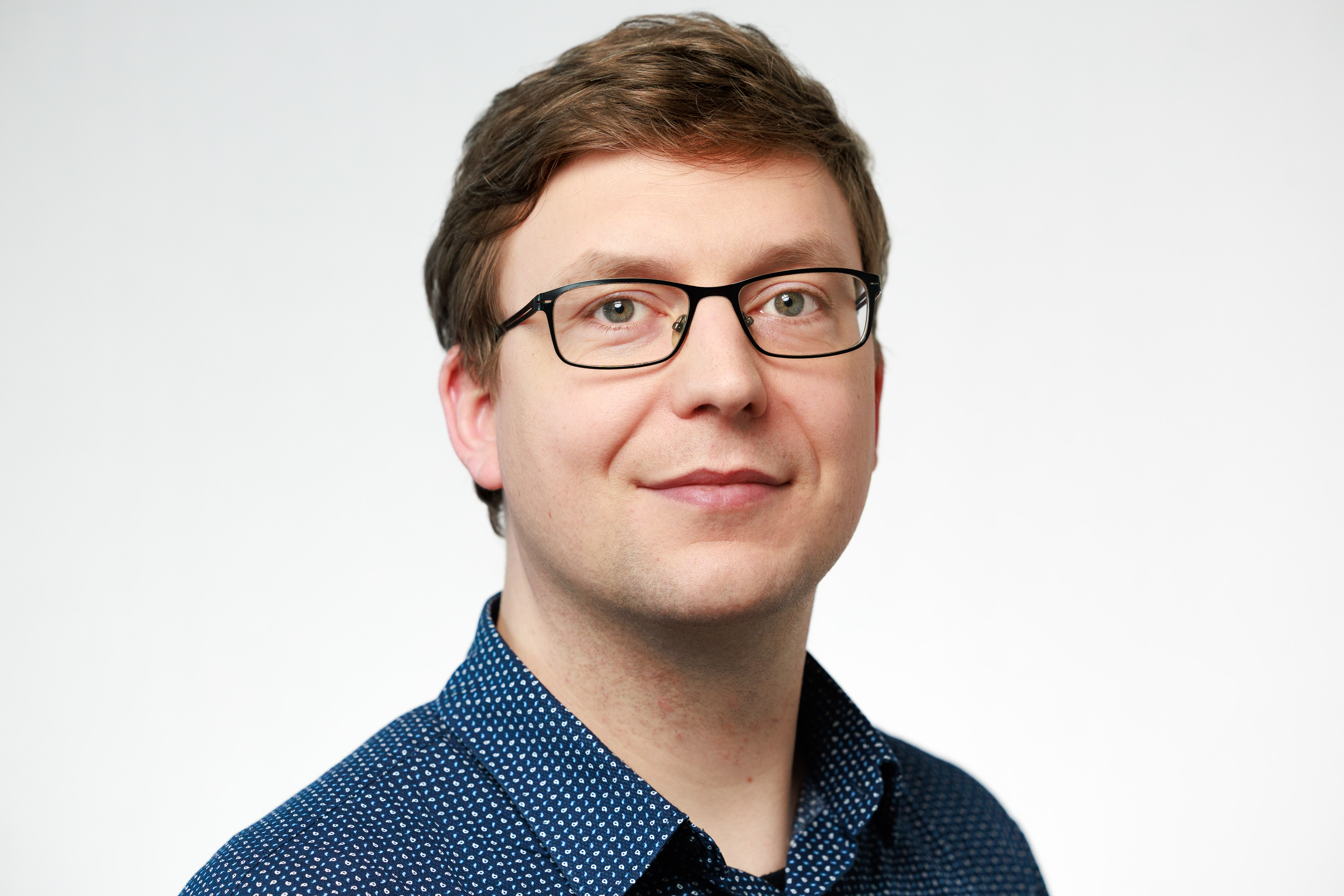 Porträtfoto Mann mit Brille und dunkelblonden Haaren