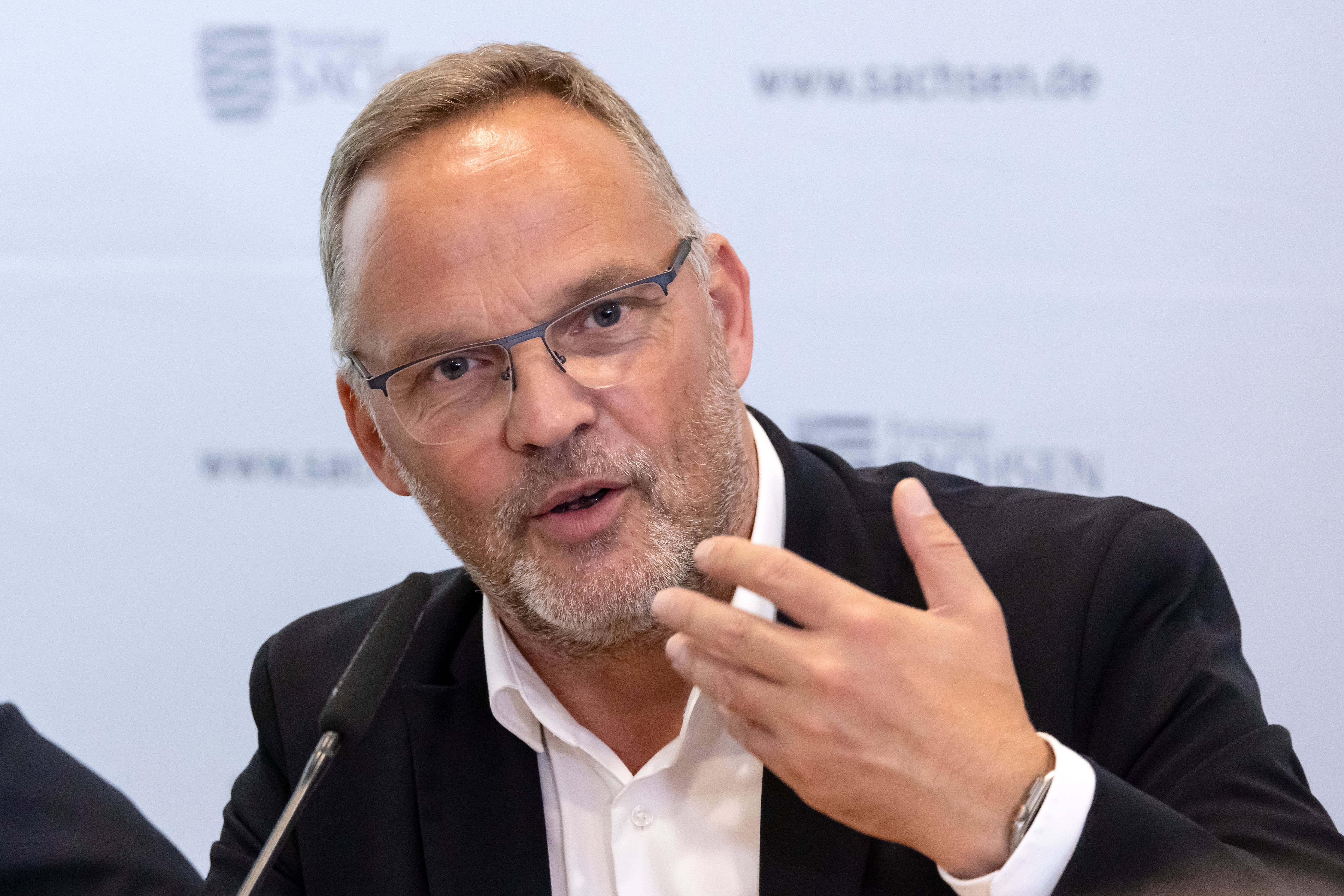 Mann im Anzug spricht in ein Mikrofon