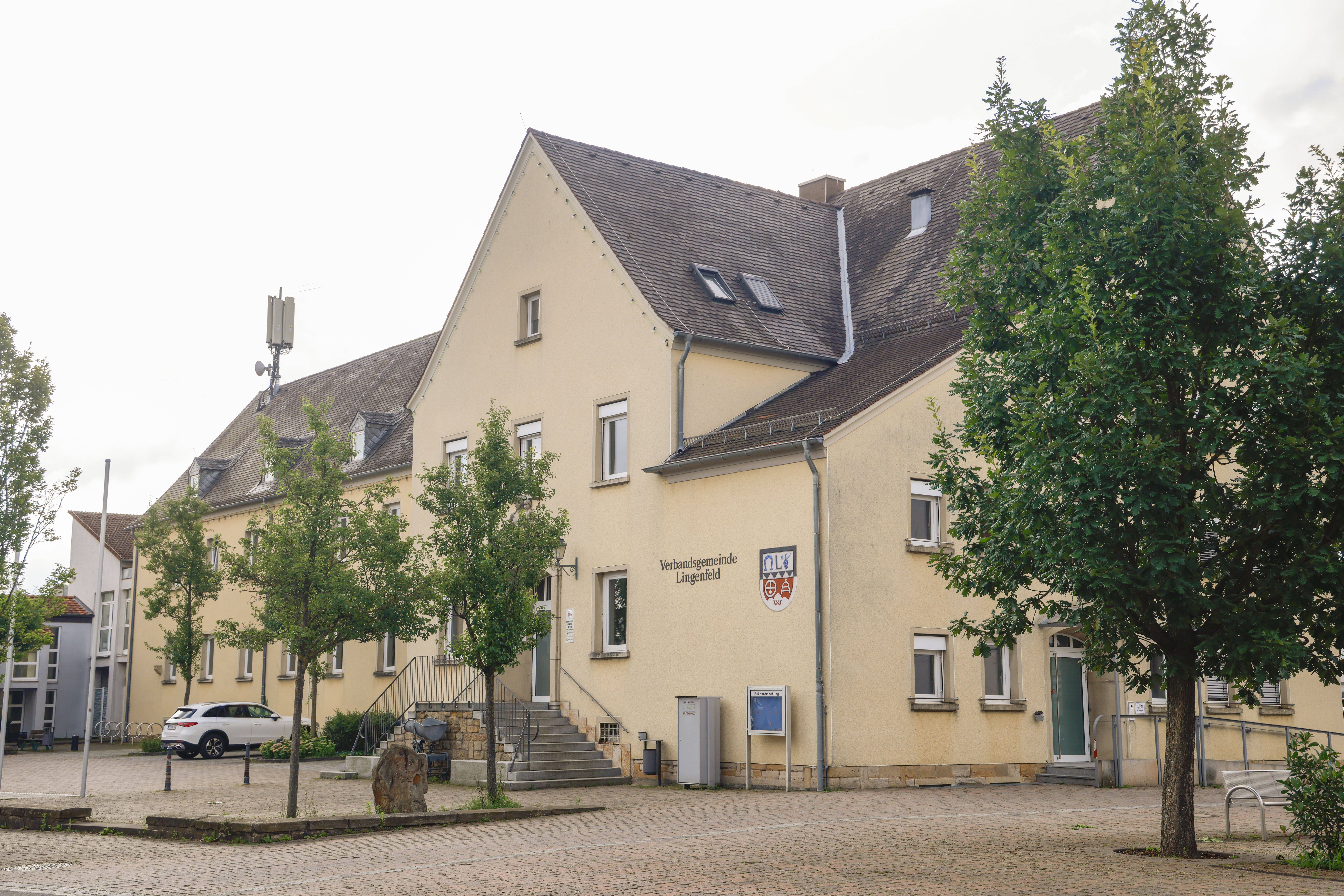 Rathaus mit gelber Fassade und Bäume