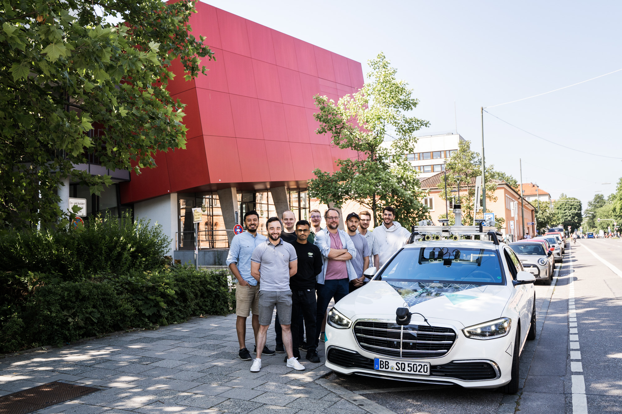 Gruppenfoto neben einem weißen Auto