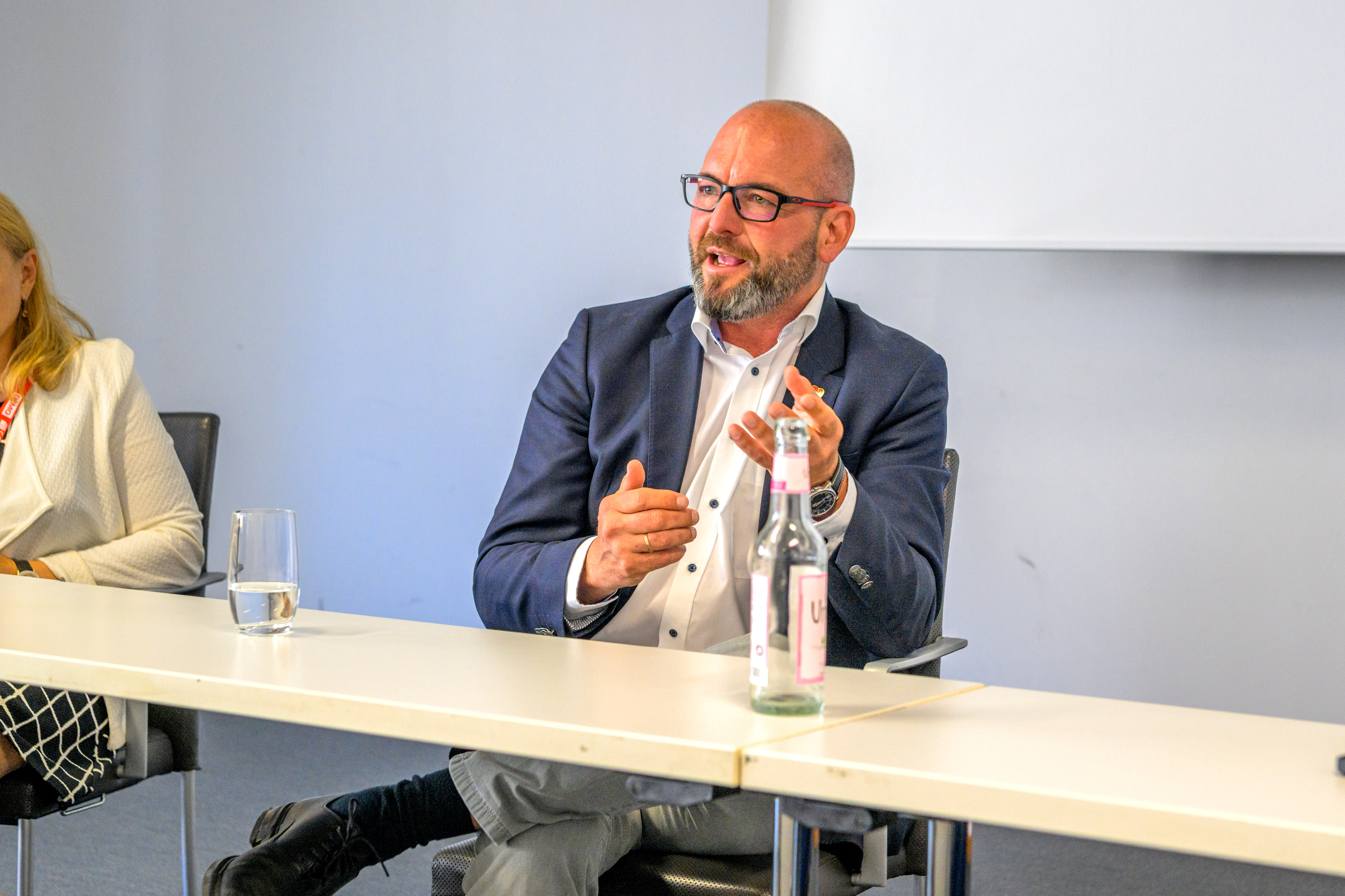 Ulf Daude sitzt auf einem Podium beim DEMO-Kommunalkongress