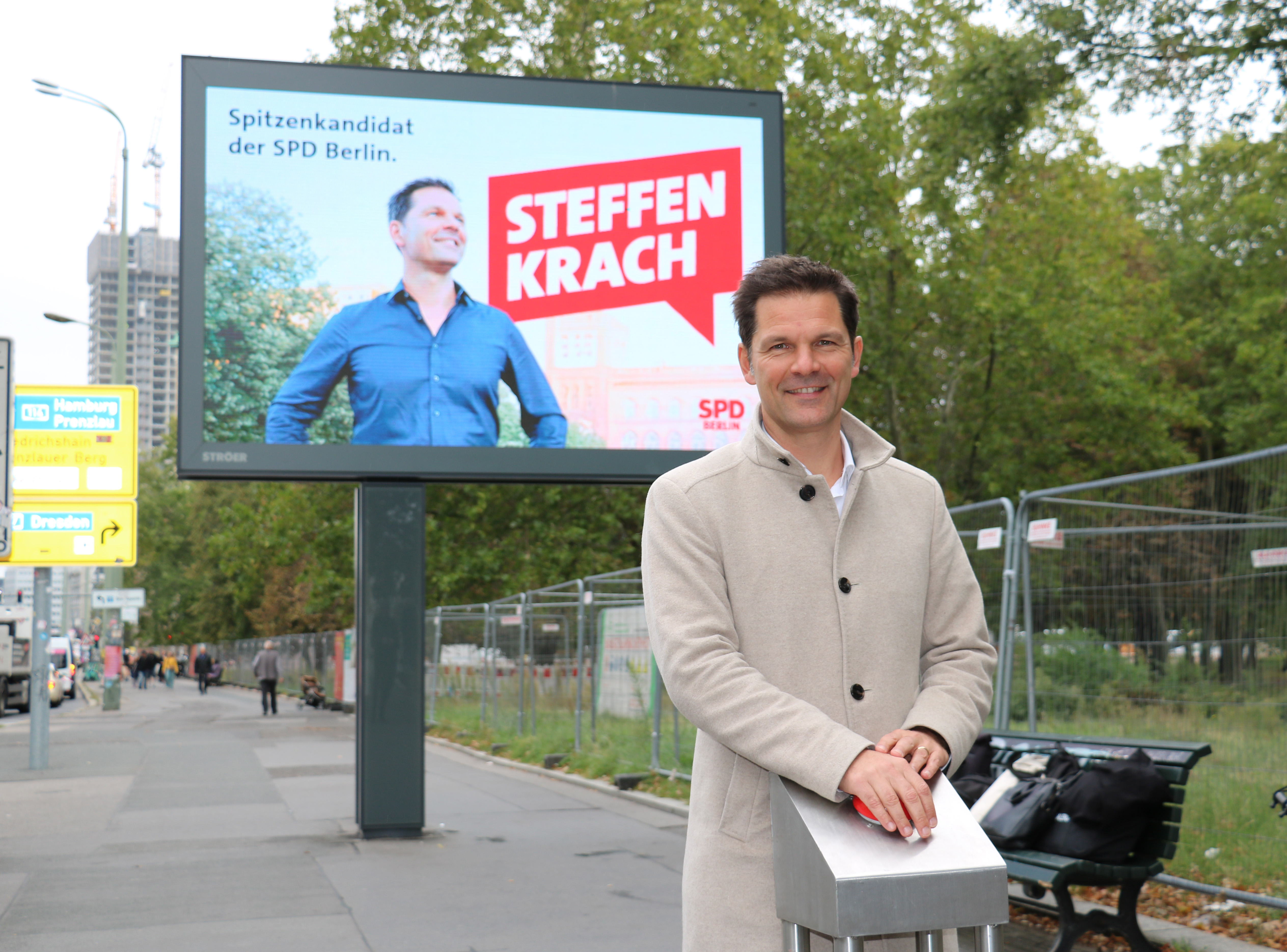 Steffen Krach drückt einen roten Knopf
