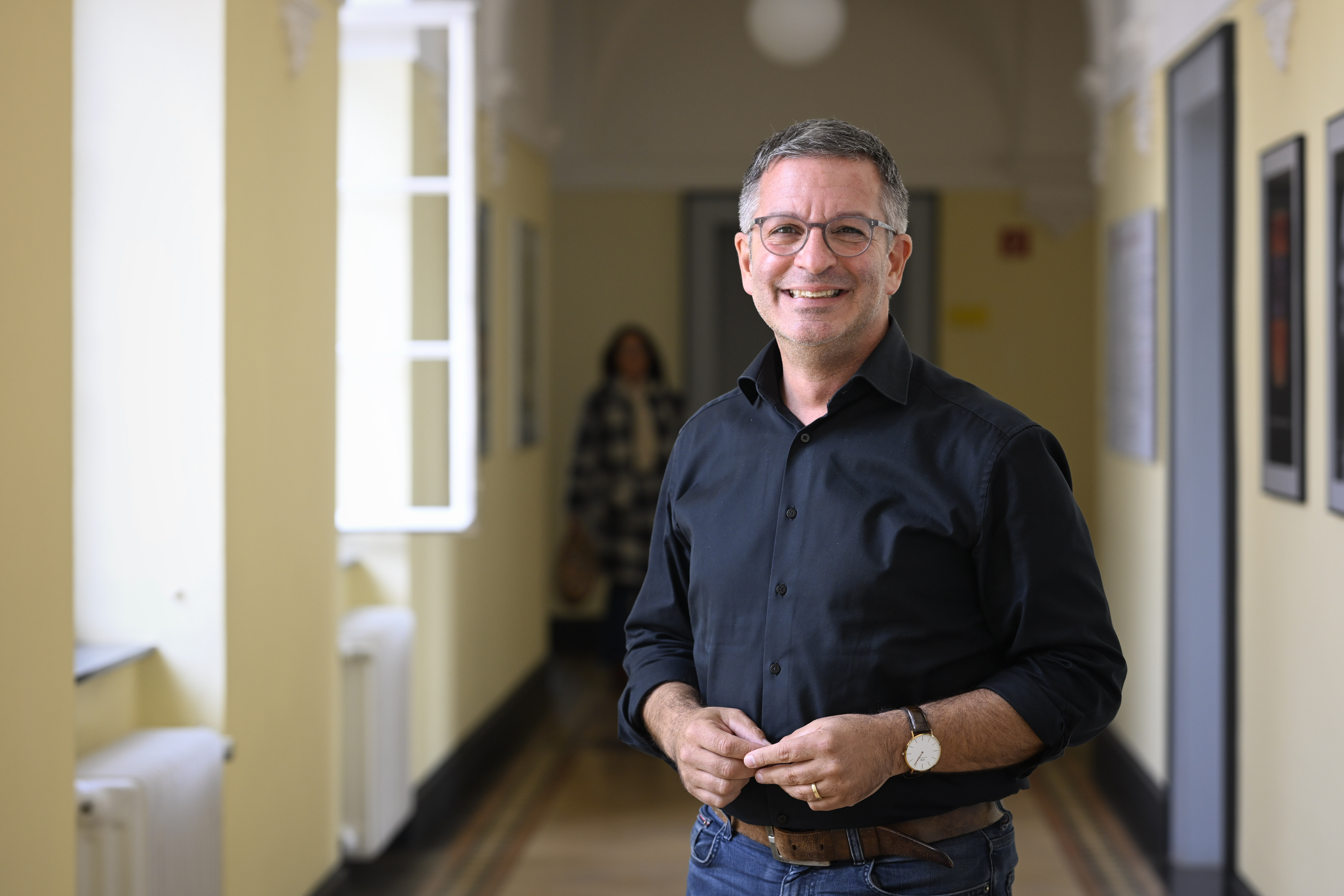 Marc Herter in einem Gebäudegang neben Fenstern